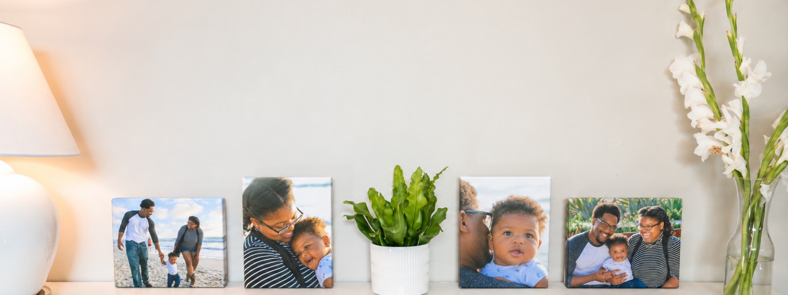 Four family canvas prints in different sizes along a shelf