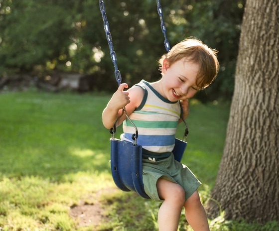 A canvas print of a smiling toddler on a backyard swing