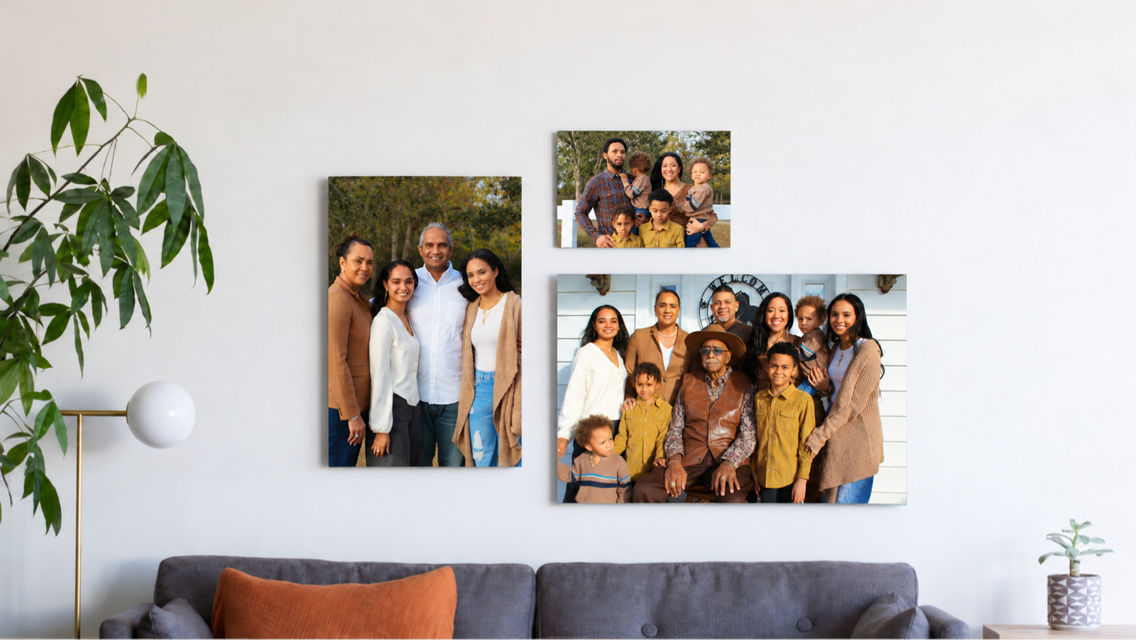 Three family metal prints of a big family gathering hanging above a gray sofa