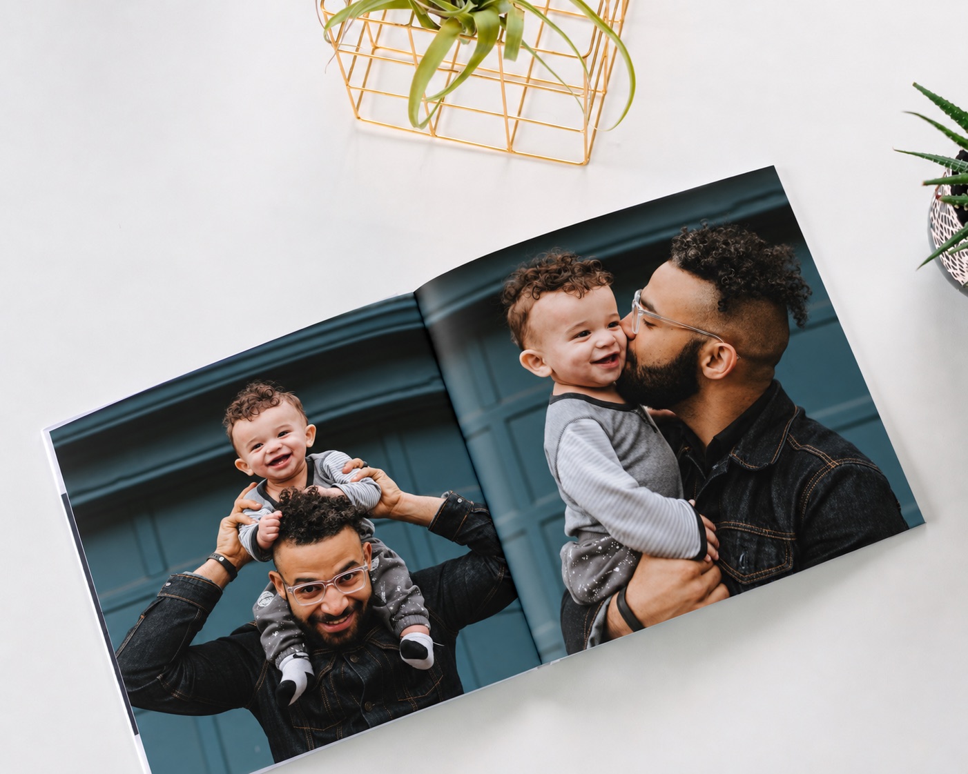 A family photo book open to two photos of a dad and his toddler son