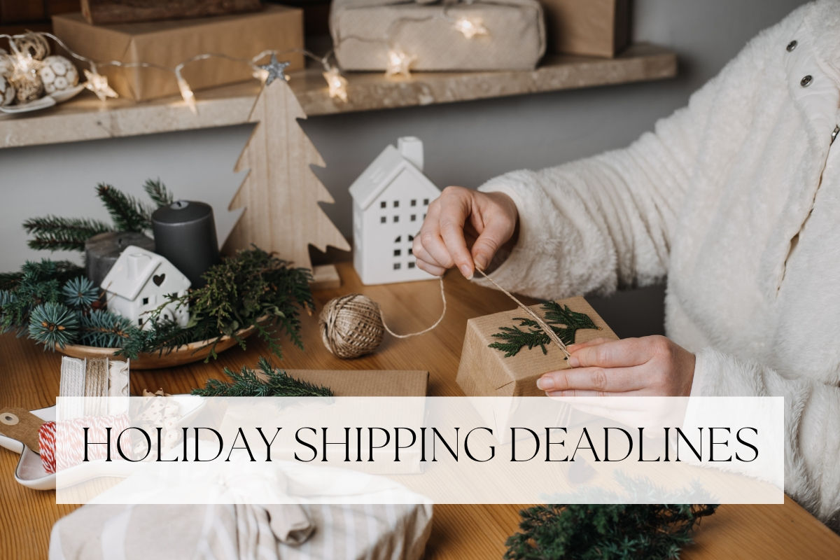 Hands tying twine around a present wrapped in brown paper with a pine sprig, beside a wooden Christmas tree and string lights, under the words Holiday Shipping Deadlines