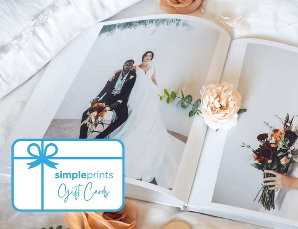 A SimplePrints gift card lying on an open wedding photo book
