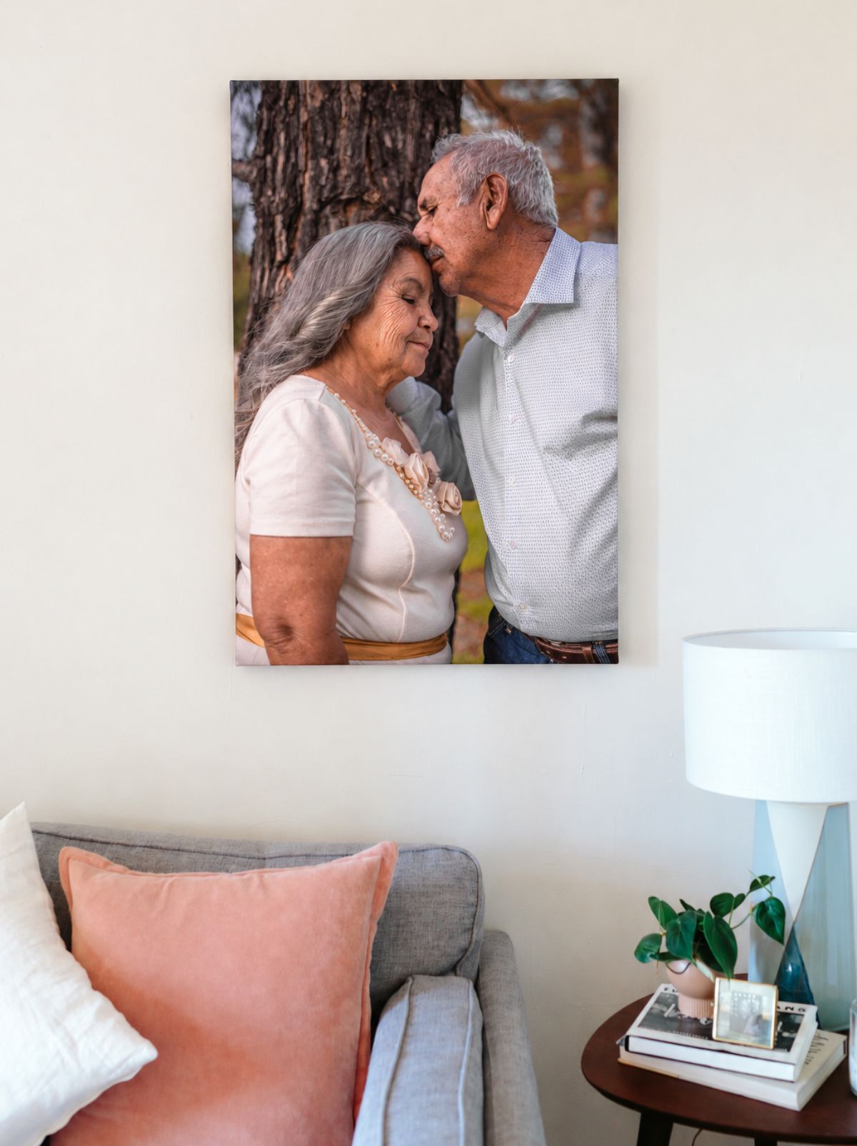 A canvas print of an older couple sharing a tender moment, hanging above a gray sofa