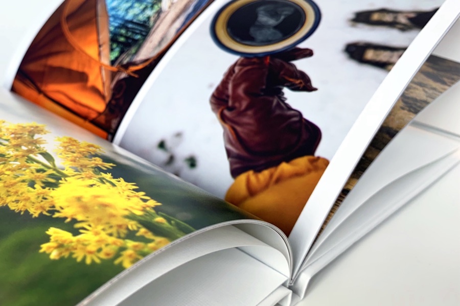 Close-up of a hardcover photo book's pages turning over at the spine