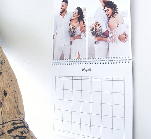 A wall calendar open to May, with two wedding photos above the month