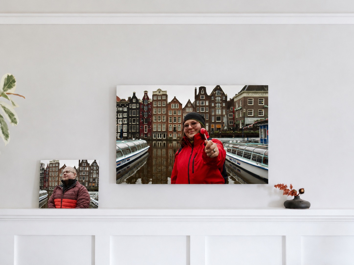 Two travel canvas prints of a woman in a red jacket in Amsterdam, hanging above a white mantel