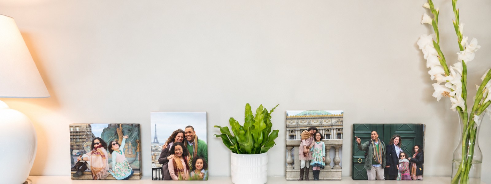 Four travel canvas prints of a family trip to Paris, in different sizes, along a shelf