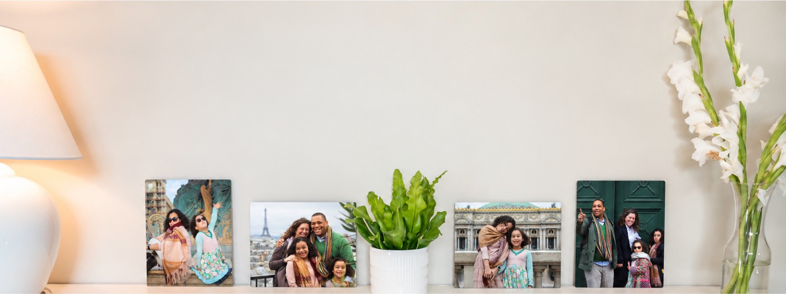 Four travel metal prints of a family trip to Paris, in different sizes, along a shelf