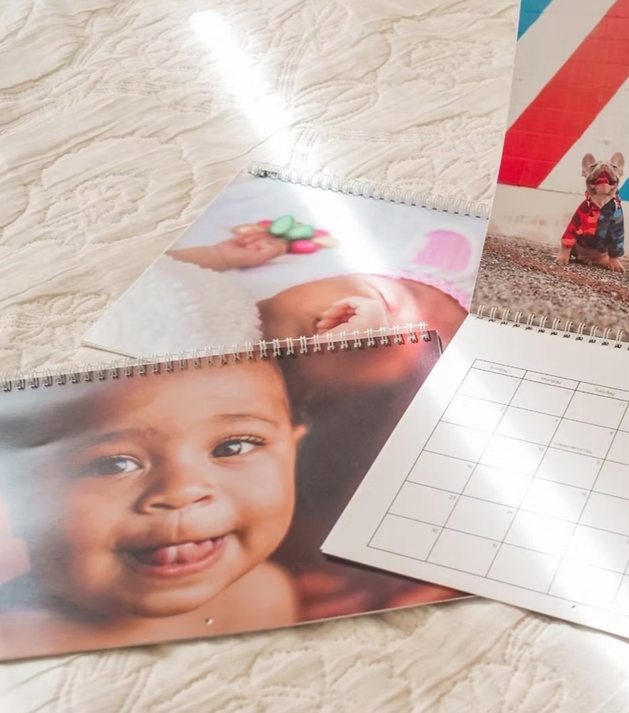 Three wall calendars lying on a bedspread